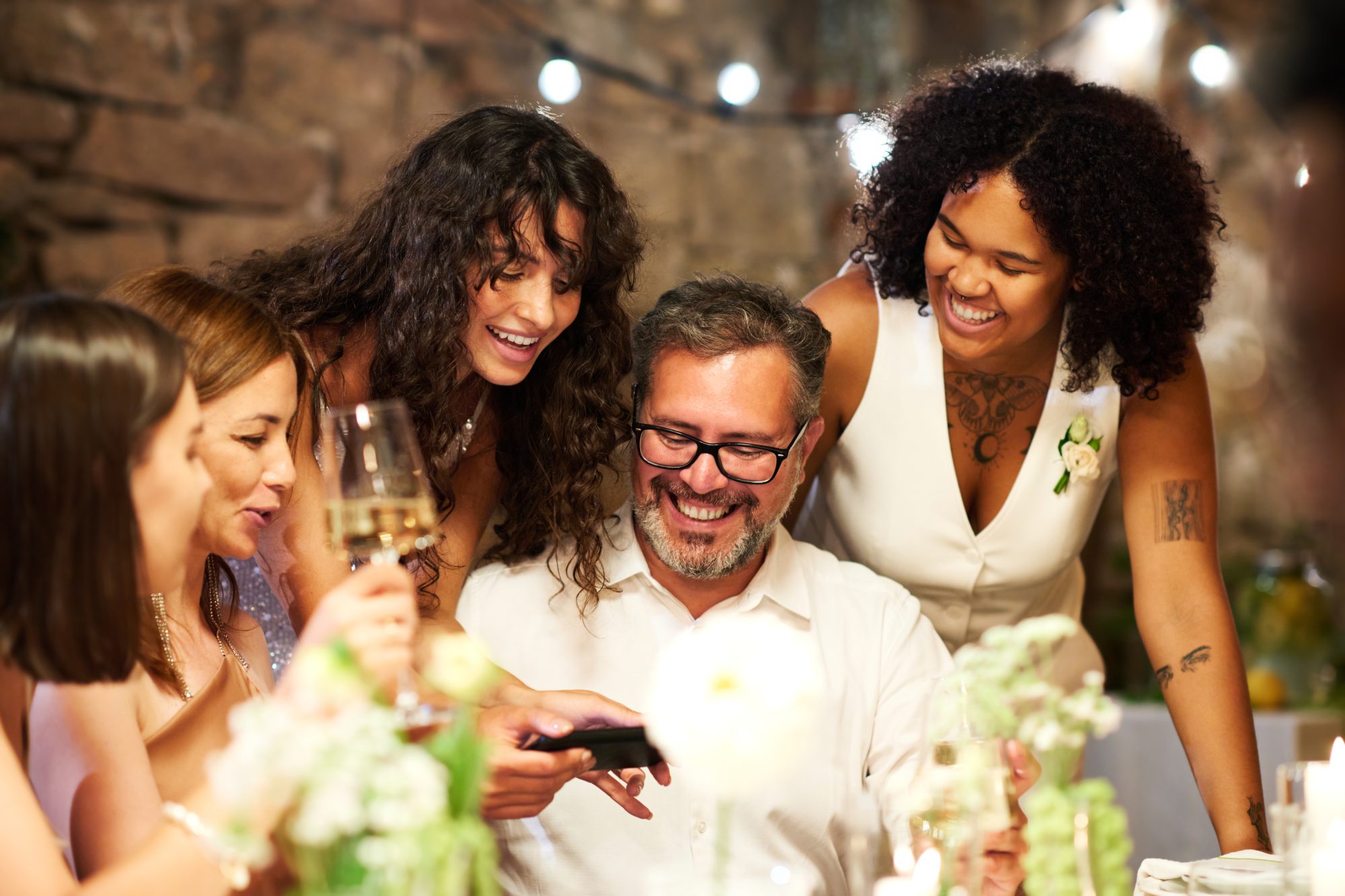 Group of wedding guests checking a photo upload page on a phone